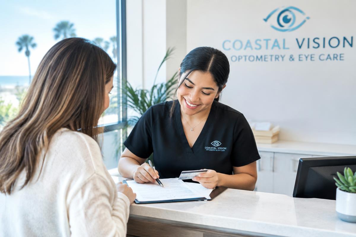 Friendly staff member helping a patient with insurance paperwork at a bright optometry reception desk